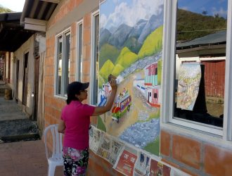 mujer pintando el mural puerto frazadas